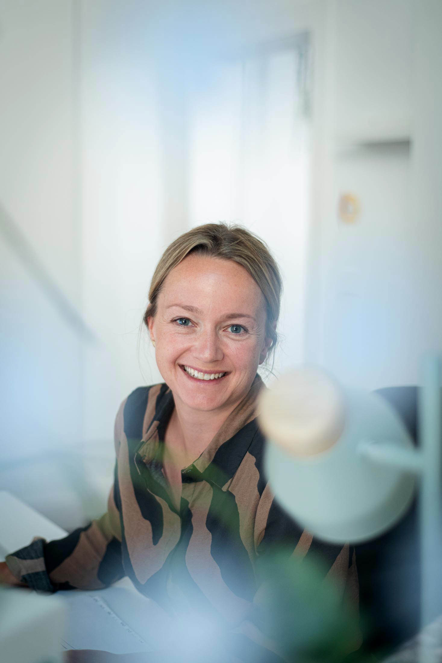 Portrait einer blonden Frau am Schreibtisch