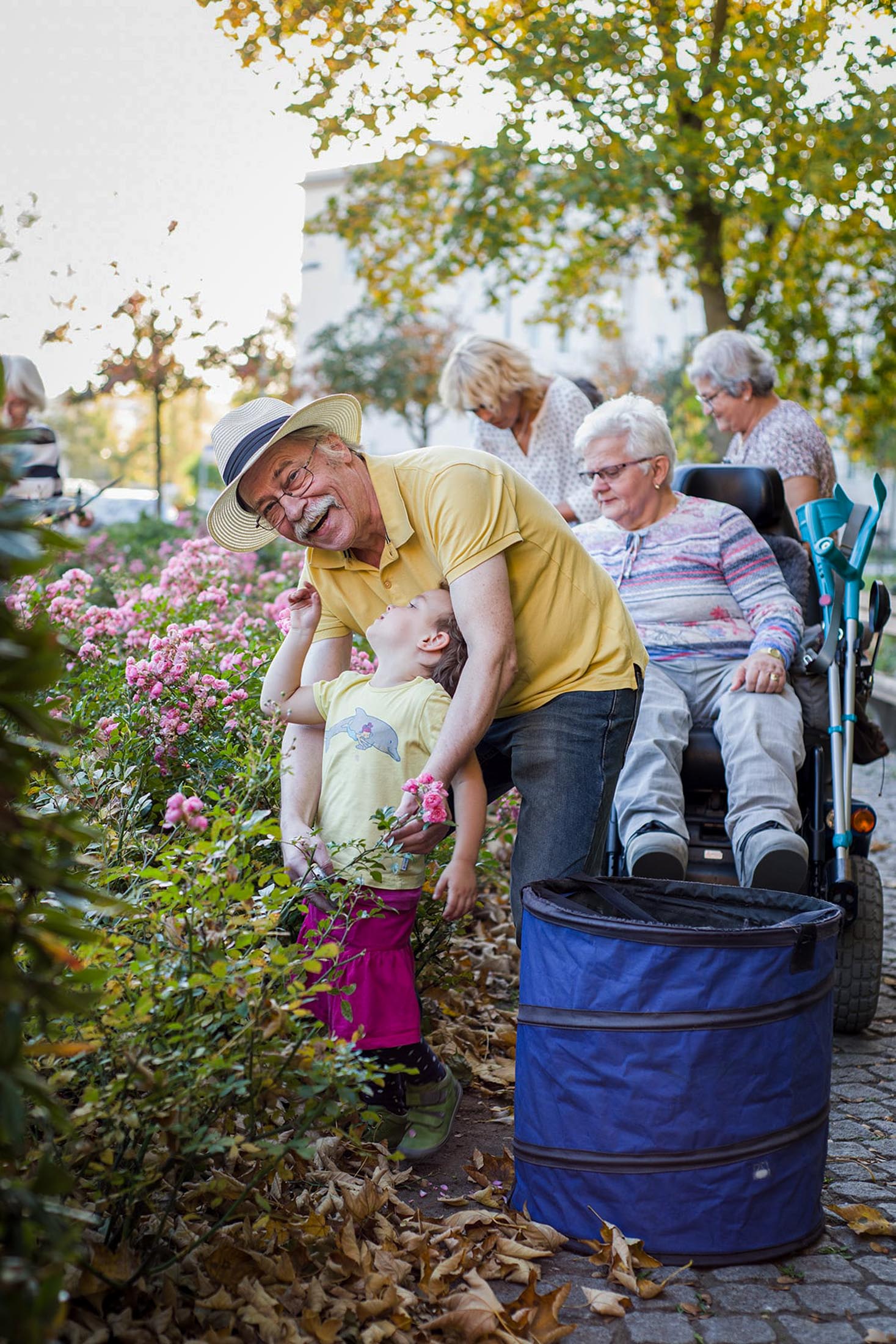 Kinder und Erwachsene bei einer Gartenaktion mit Pflanzenkübeln