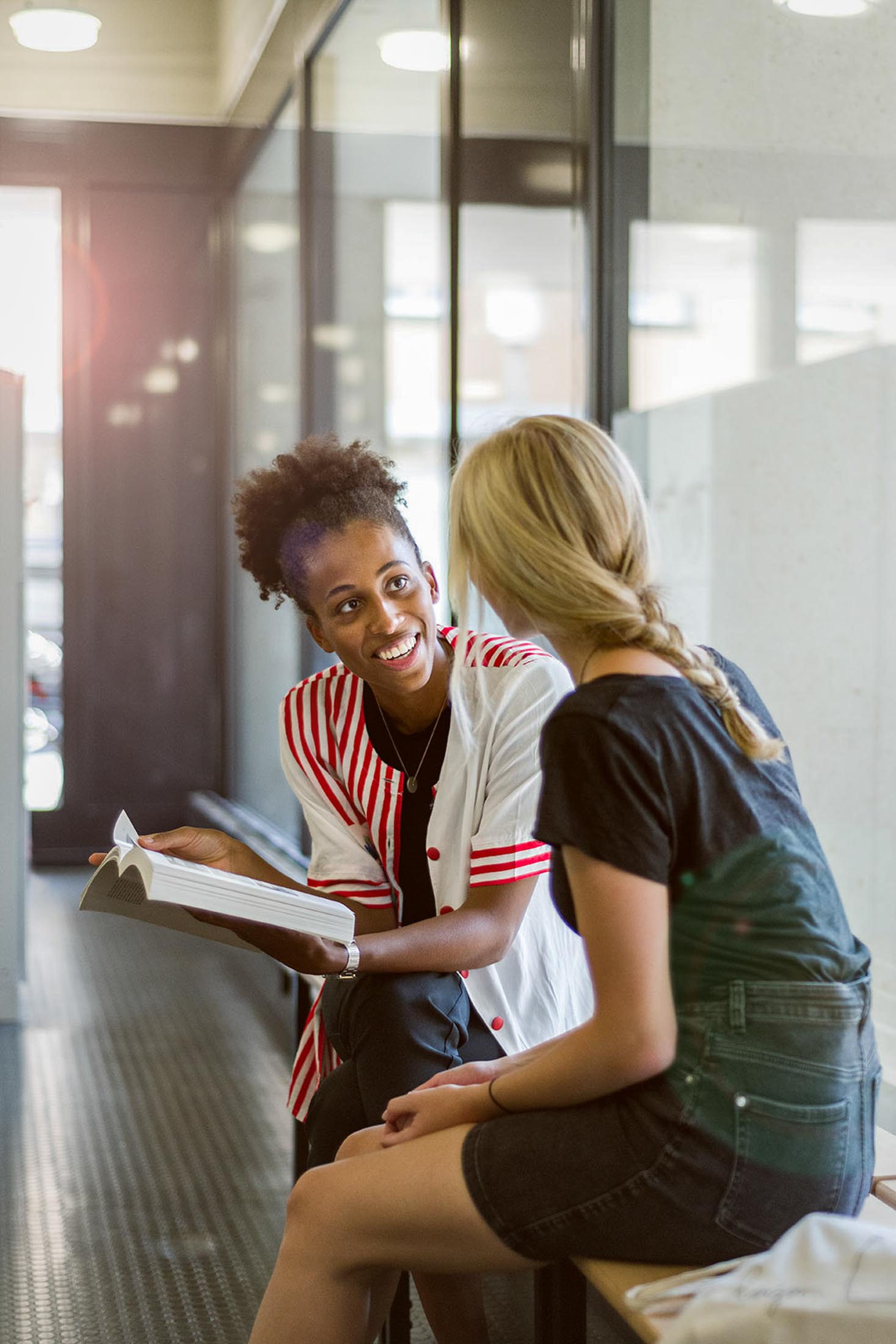 Zwei Studentinnen unterhalten sich im Uni-Foyer