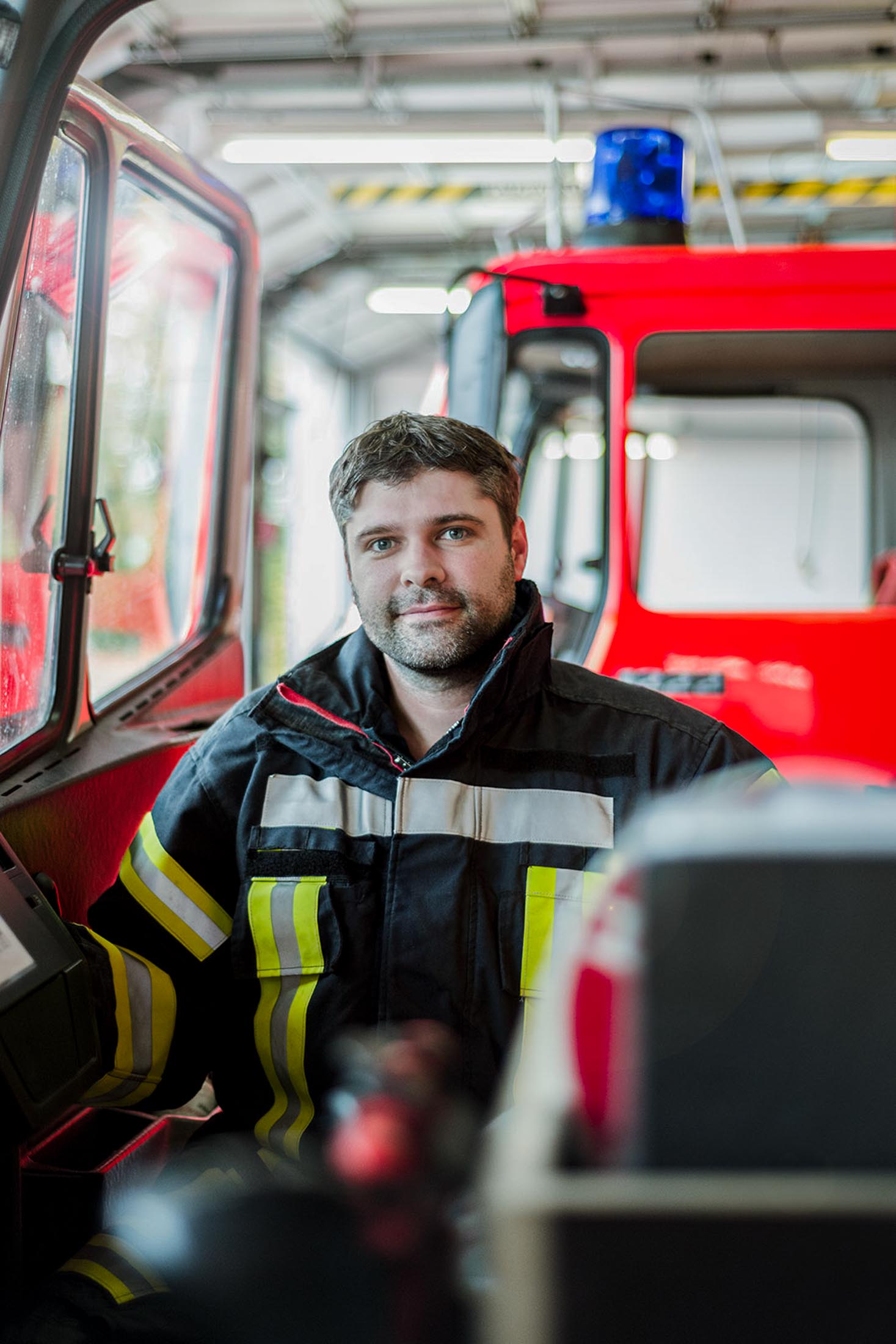 Feuerwehrmann in Schutzkleidung vor einem Einsatzfahrzeug