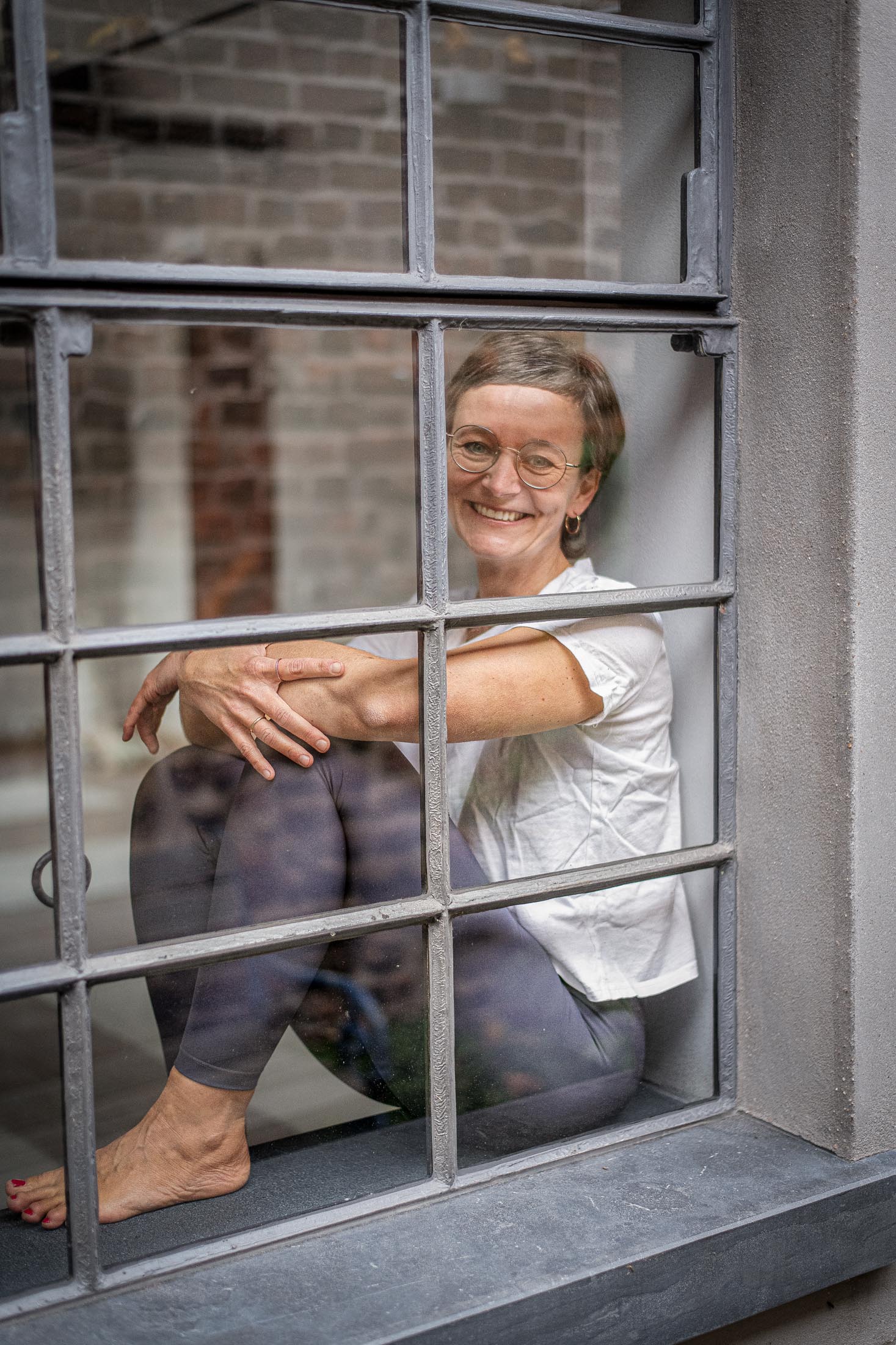 Porträt der Yogalehrerin durch ein Fenster fotografiert