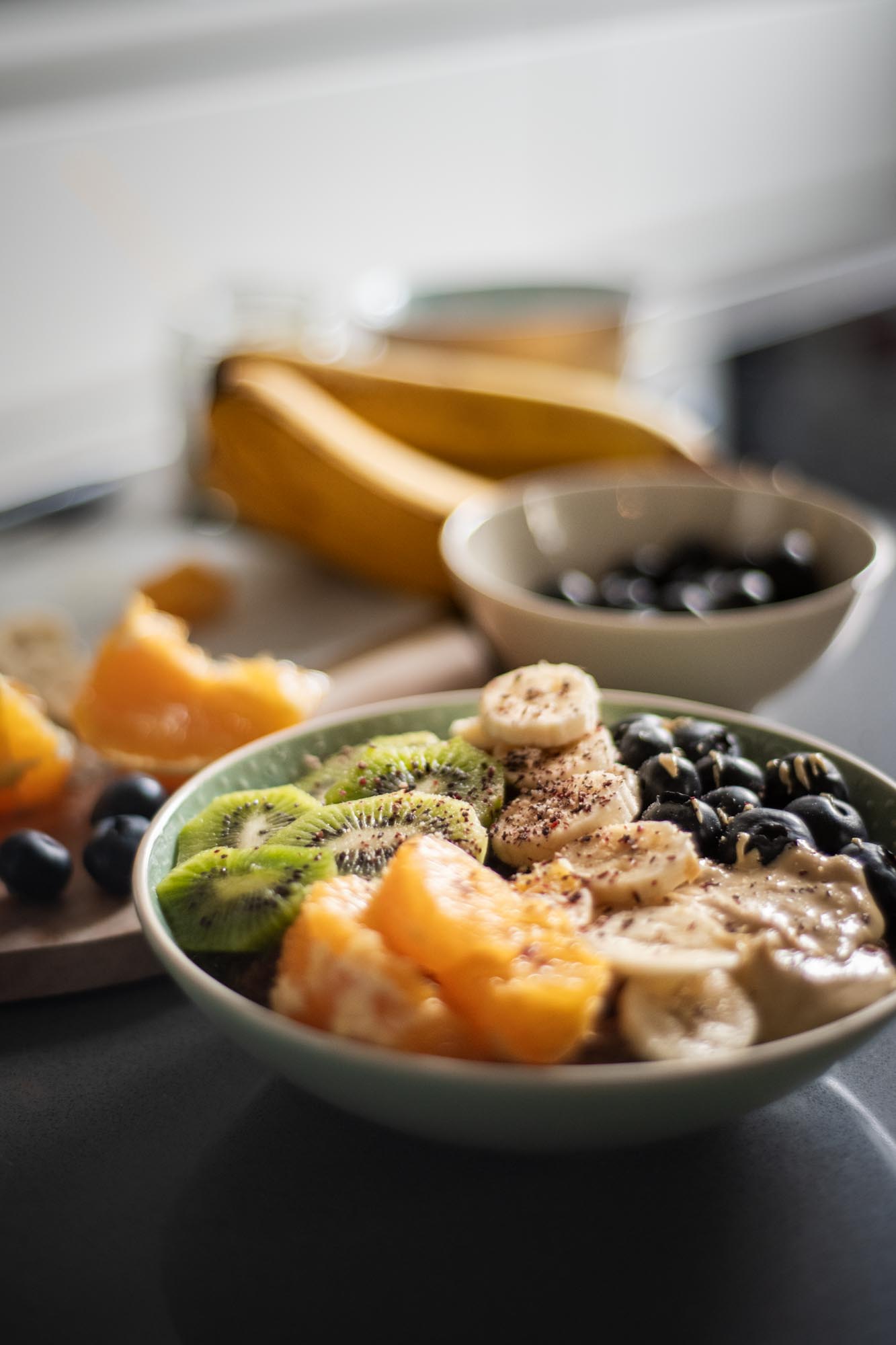 Nahaufnahme einer Frühstücksbowl mit Banane, Beeren und Toppings