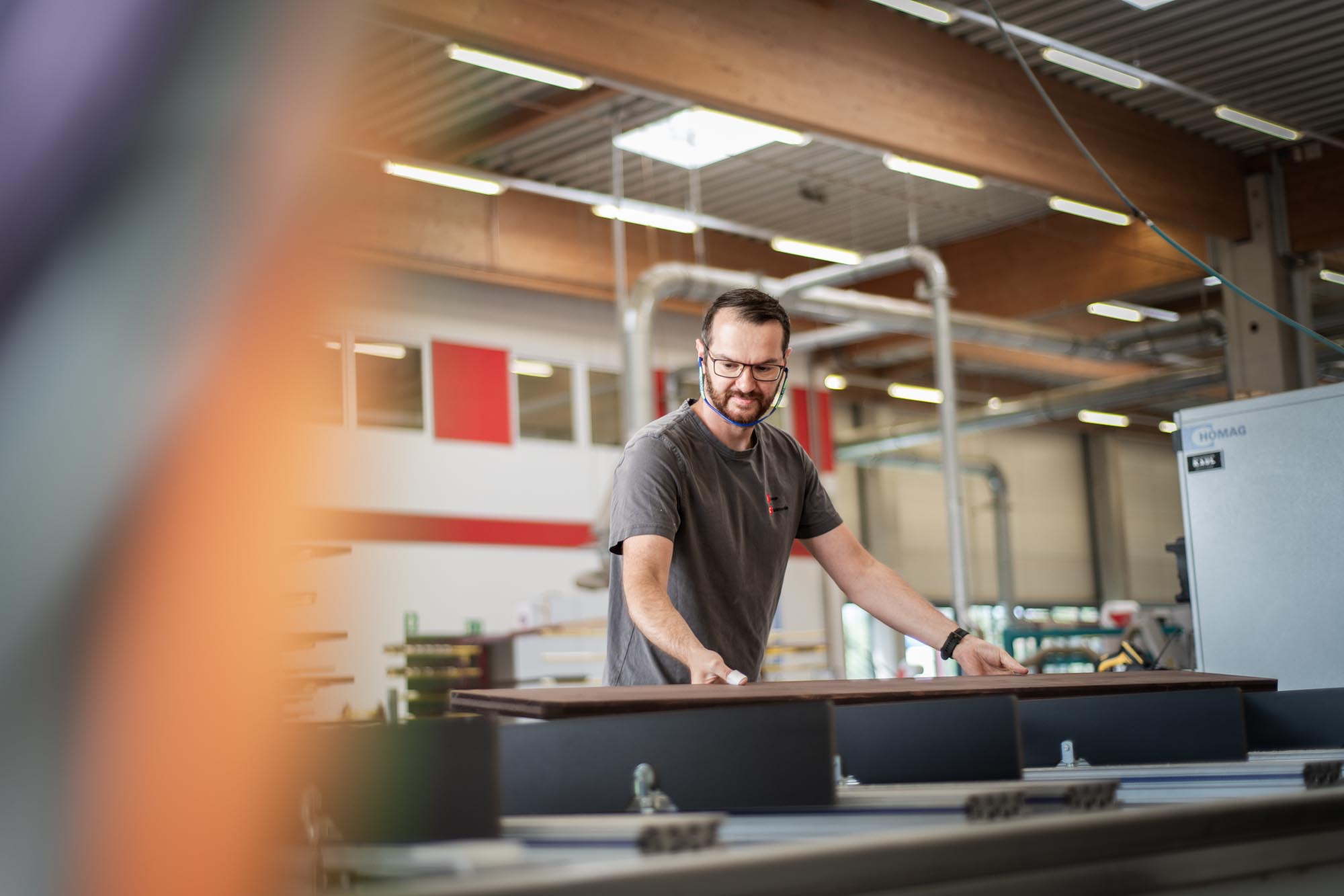 Mann arbeitet an großer Maschine in Industriehalle