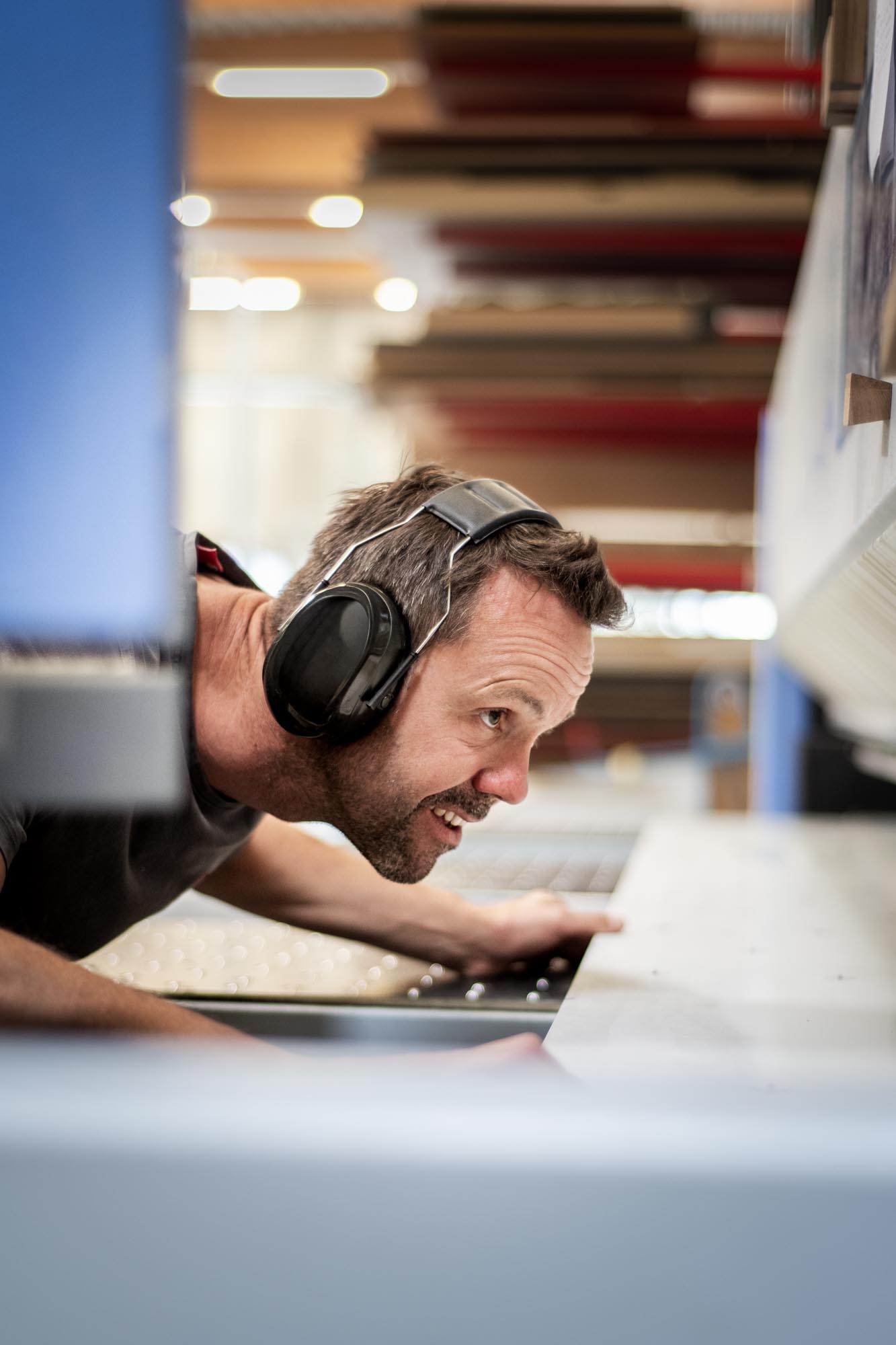 Handwerker mit Gehörschutz arbeitet konzentriert an Maschine