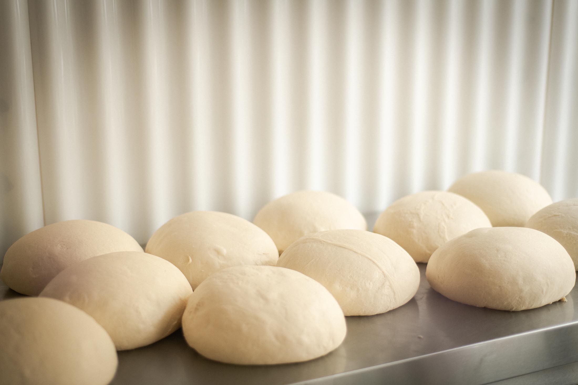 Gleichmäßig geformte Teiglinge liegen in Reihen auf einem Arbeitstisch